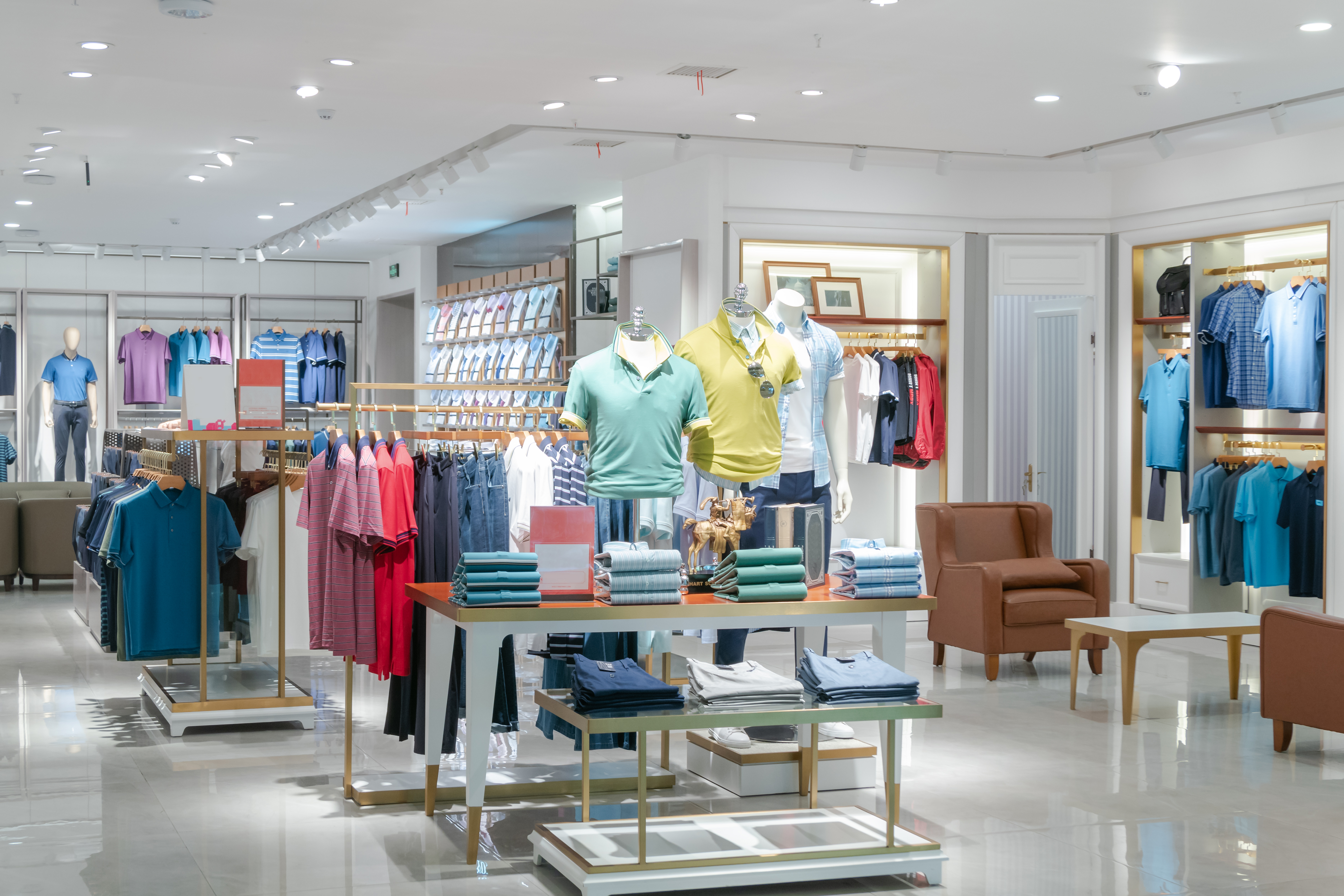 A stylish clothing store interior showcasing folded fashionwear, modern racks, and vibrant lighting. London, UK, 21 May 2023